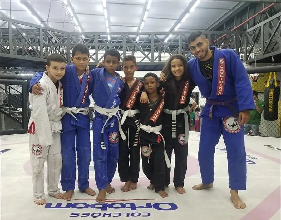 Crianças de quimono com medalhas ao lado do professor